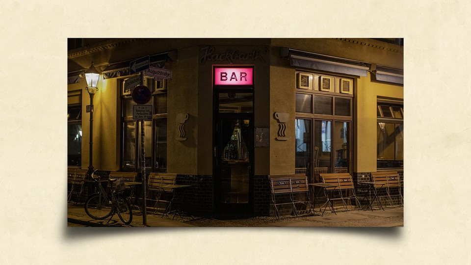 Un bar la nuit avec une enseigne rose illuminée au centre
