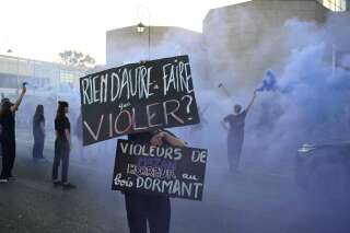Des militantes féministes montrant des pancartes devant le tribunal