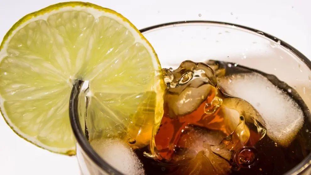 Un refresco con hielo y una rodaja de limón.