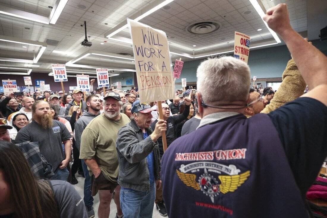 Terry Muriekes, un travailleur de stockage d'outils chez Boeing, tient une pancarte lors d'un rassemblement de grève à Seattle.