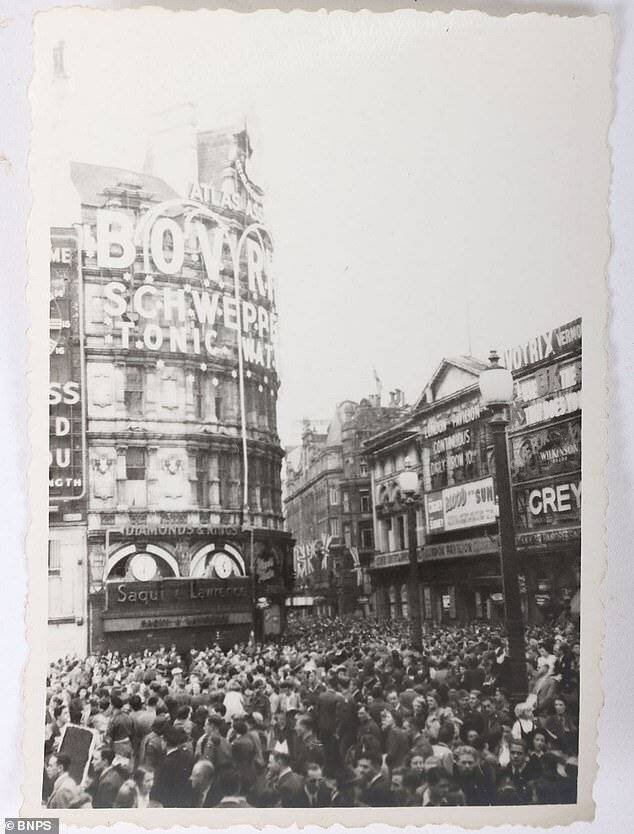 Foules célébrant la reddition de l'Allemagne à Leicester Square.