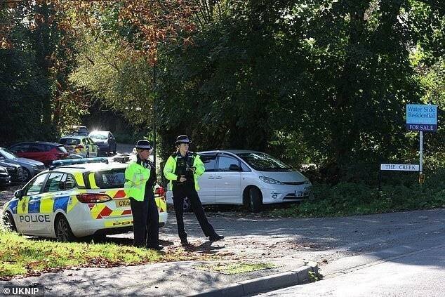 Agents de police près du lieu où le bateau a chaviré. Un corps a depuis été récupéré dans la rivière