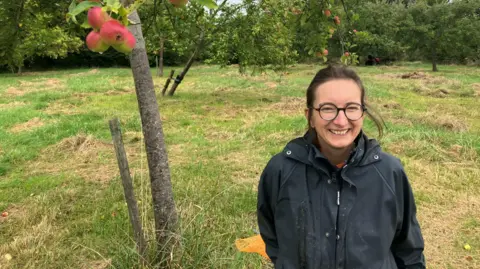 Une femme dans un verger de pommiers