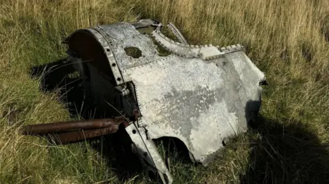 Wreckage of the cockpit lying on green grass