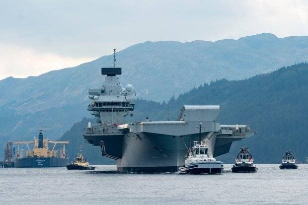 Un grand navire remorqué par des remorqueurs dans l'eau