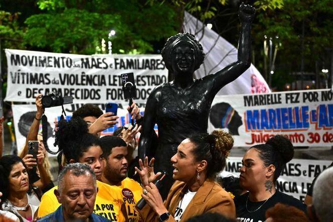Anielle Franco, sœur de Marielle Franco et ministre de l’égalité raciale (au micro), aux côtés de son père Antonio Franco (à gauche), devant une statue en l’honheur de la défunte militante, dans le centre-ville de Rio de Janeiro, le 31 octobre 2024.