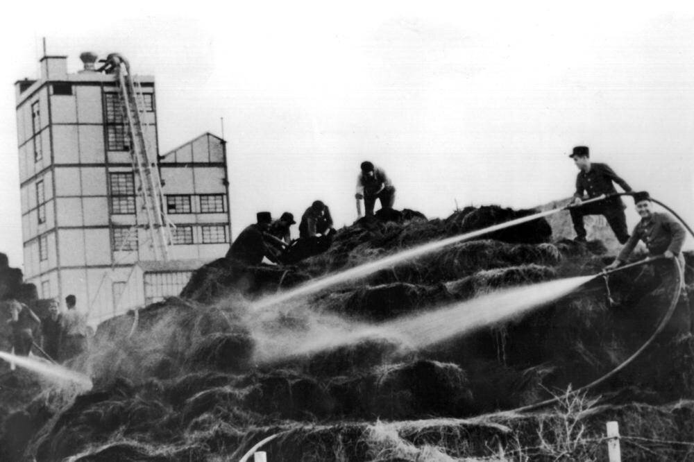 Les pompiers éteignant l'incendie d'une usine de papier après une attaque.