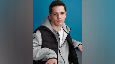 Elliot Caswell regarde la caméra