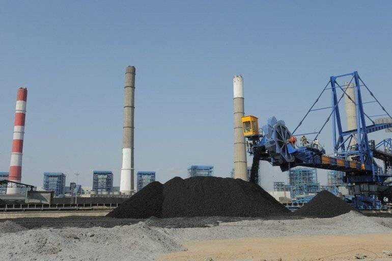 Travailleurs utilisant des machines lourdes à la centrale thermique Adani