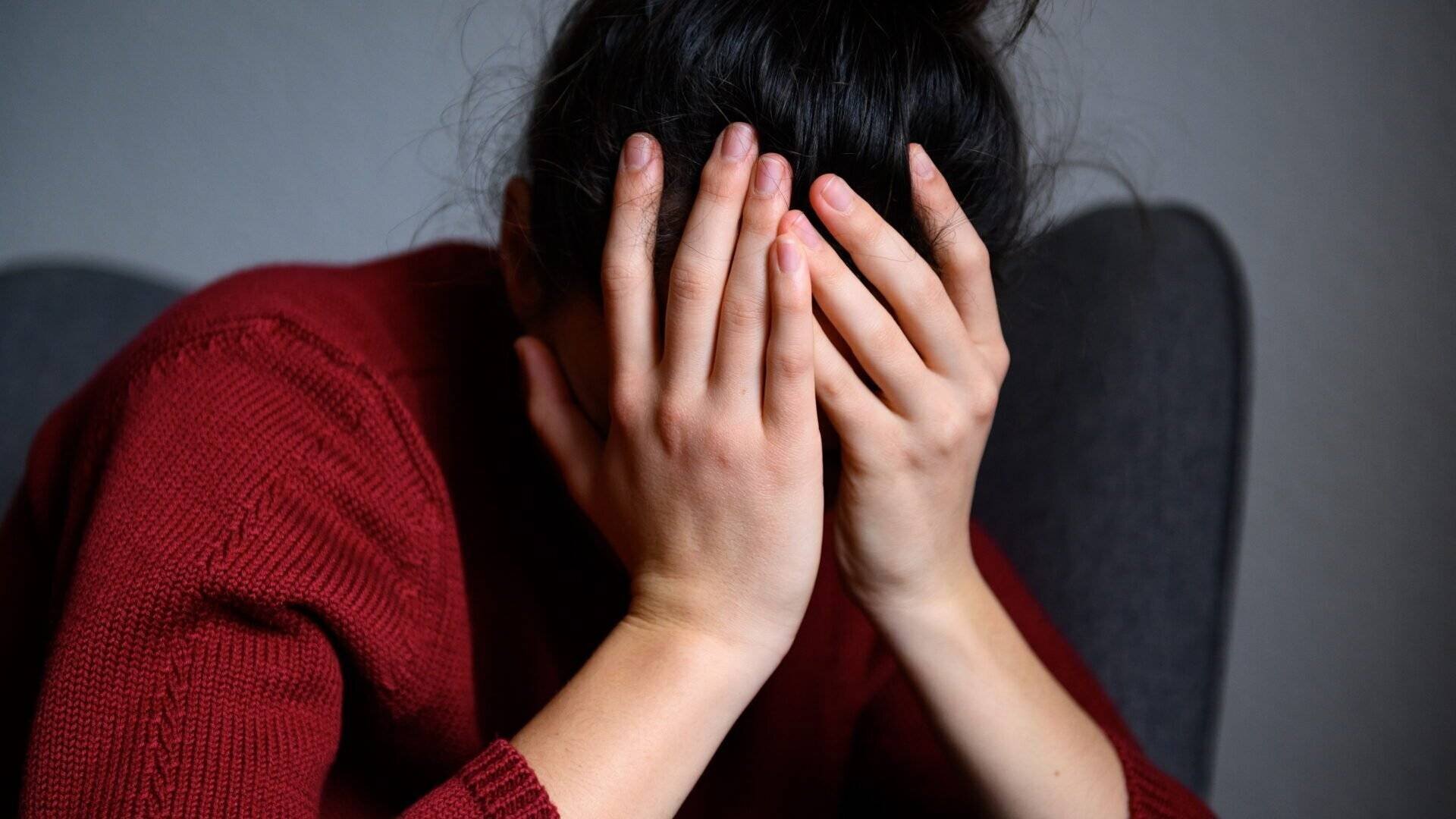 Une femme assise, la tête dans les mains