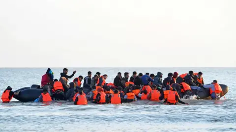 Des migrants tentant de monter à bord d'un bateau sur la plage de Gravelines, France.