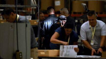 Des officiels vérifient le contenu des bulletins dans un bureau de vote à Philadelphie, le 5 novembre 2024. (HEATHER KHALIFA / GETTY IMAGES NORTH AMERICA / AFP)
