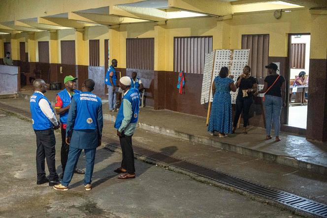 Des observateurs électoraux à l’extérieur d’un bureau de vote, à Libreville, le 16 novembre 2024.