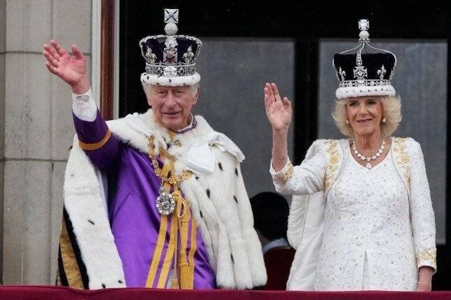 Le roi Charles III et la reine Camilla saluent la foule depuis le balcon de Buckingham Palace après la cérémonie de couronnement, le 6 mai 2023.