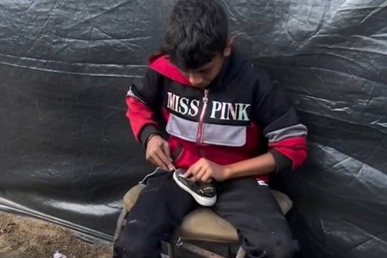 L'enfant Islam réparant des chaussures dans le camp de Yarmouk pour soutenir sa famille.