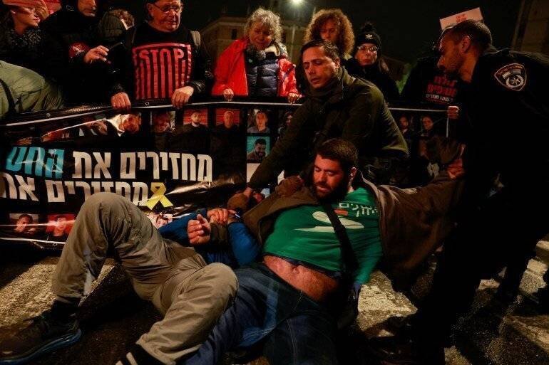 Police officers drag demonstrators as people block a road during a protest in support of the hostages kidnapped during the deadly October 7, 2023 attack by Hamas.