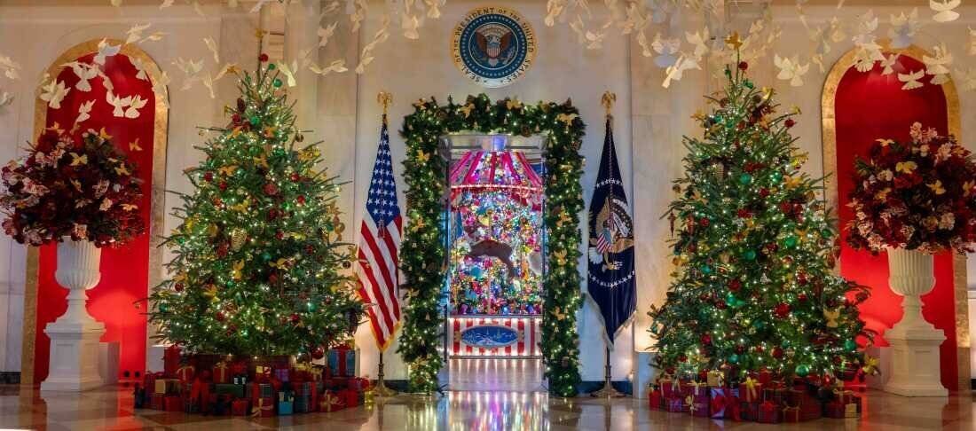 Des arbres décorés dans le hall central encadrent la porte de la salle bleue.