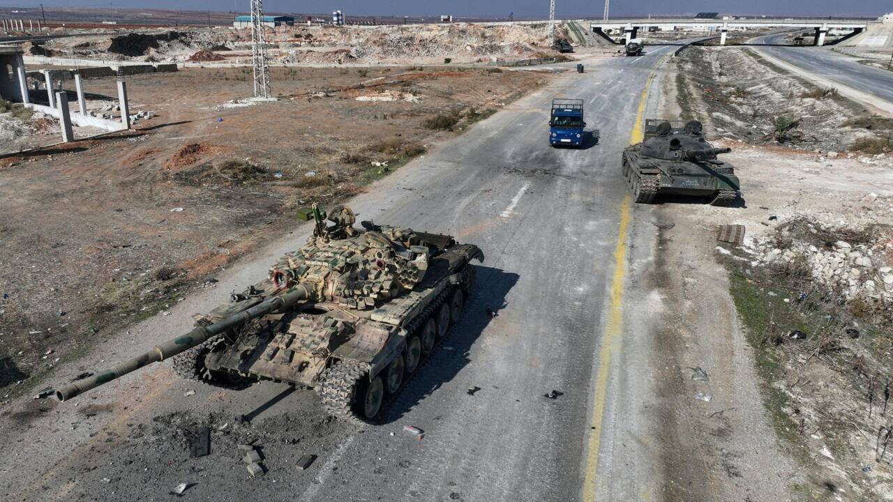 Une voiture passe devant des équipements de l'armée syrienne sur l'autoroute de Damas, près de la ville de Suran, au nord de Hama, le 3 décembre 2024.