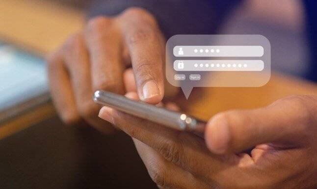 Homme d'affaires utilisant un smartphone pour accéder à un compte sur un site web en entrant un nom d'utilisateur et un mot de passe au bureau