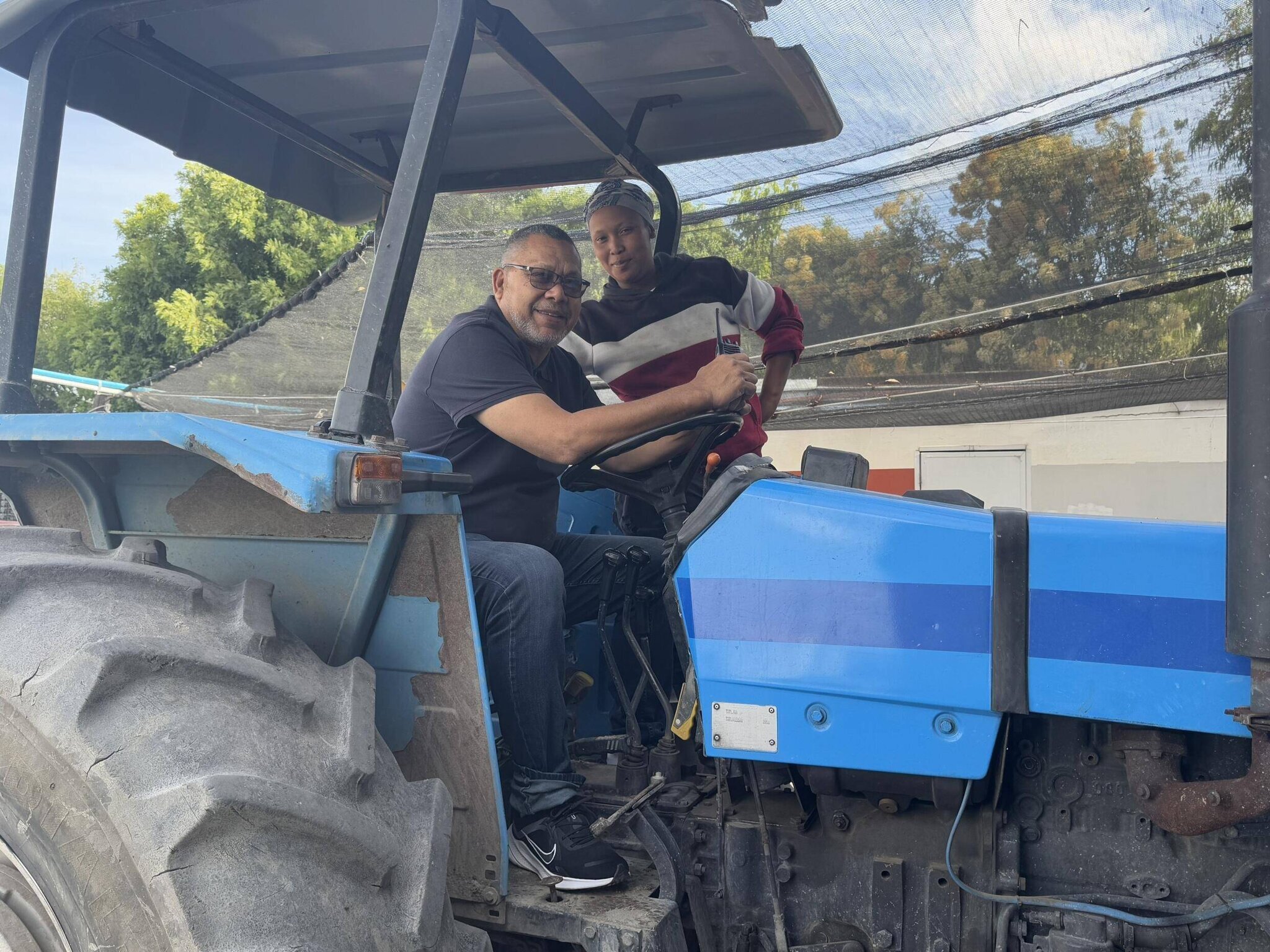 Achmad Brinkhuis à Chamomile Farm avec un des locaux qu'il emploie.