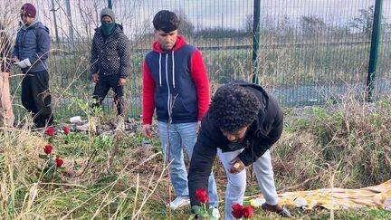 Des exilés déposent des roses, le 15 décembre 2024, à l'endroit où deux personnes ont été abattues à Loon-Plage (Nord).