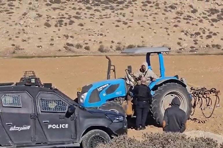 Un colon labourant des terres palestiniennes à Dahriah