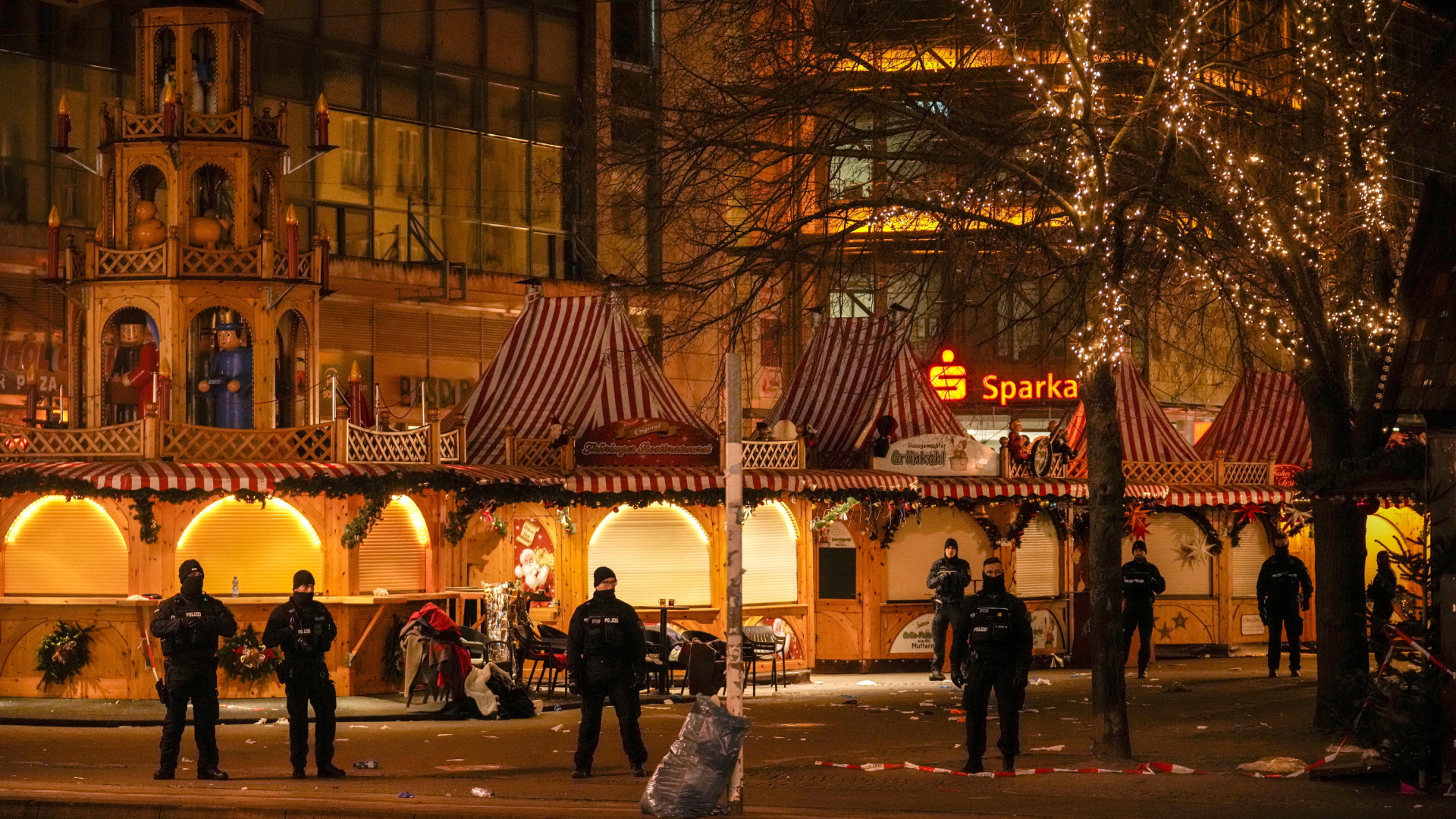 Sicherheitskräfte stehen vor einem abgesperrten Weihnachtsmarkt in Magdeburg.