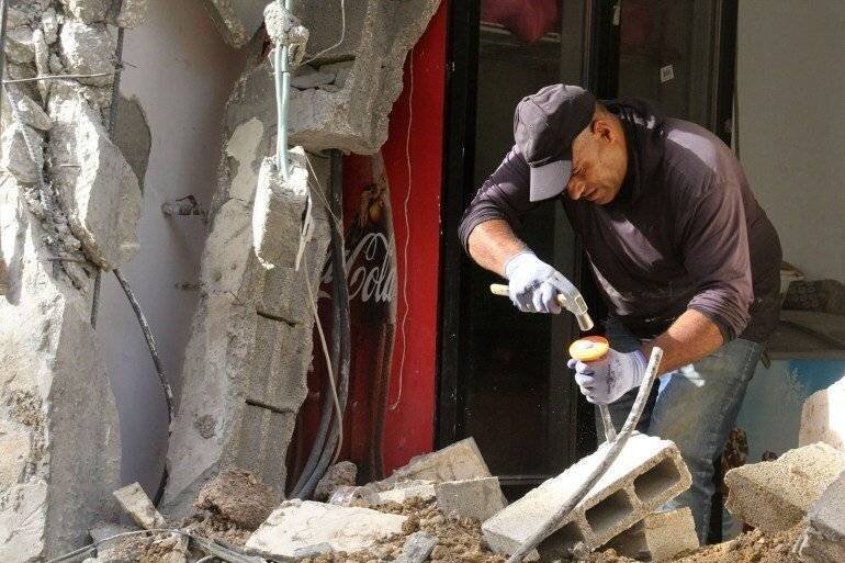 Bassem Oufi tente de réparer l'entrée de son magasin