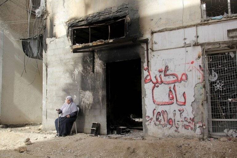 Naima Al-Saadi devant sa bibliothèque incendiée