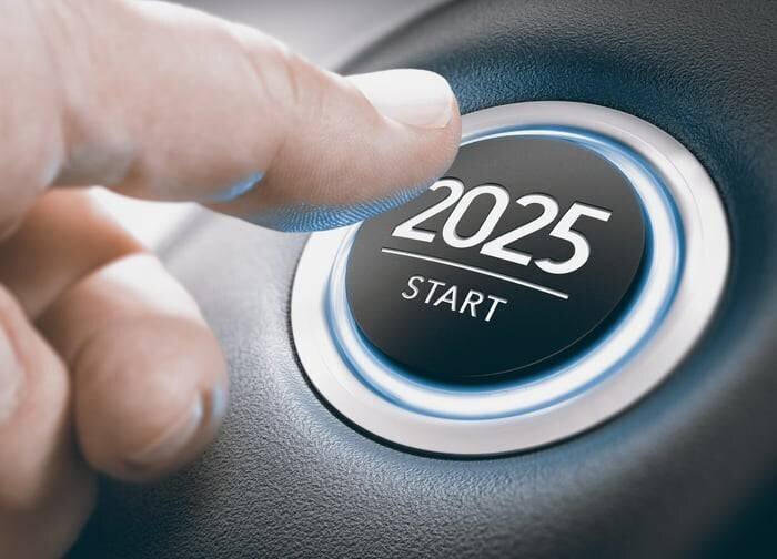 Un doigt appuyant sur le bouton de démarrage d'une voiture avec 2025 dessus.