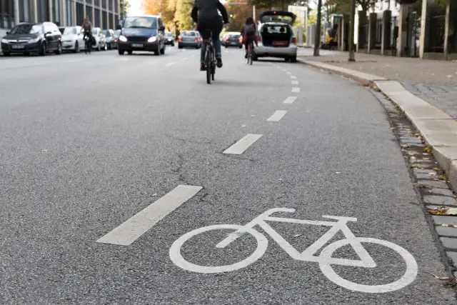 Un coche parado obstaculizando un carril bici.