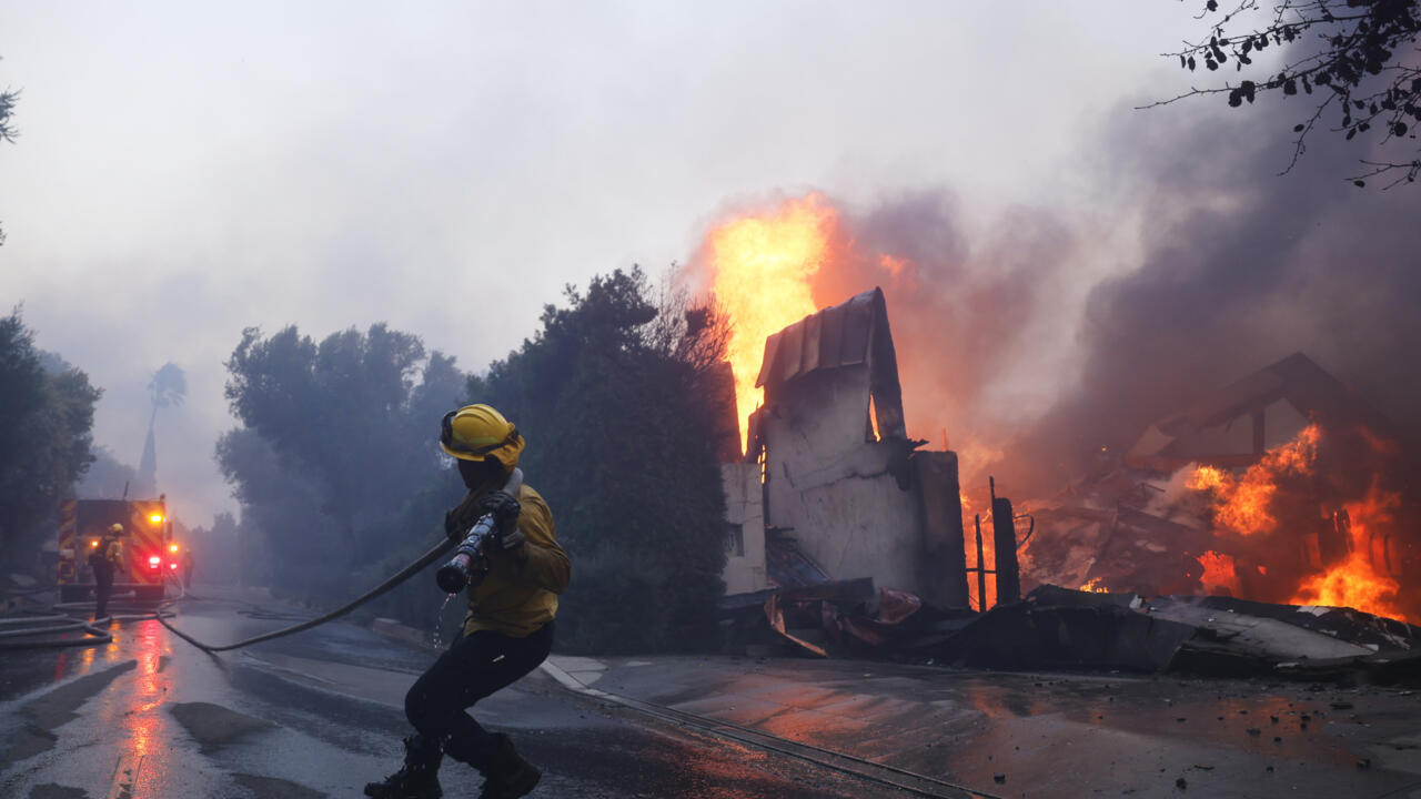 Un pompier se bat contre les flammes, qui brûlent un bâtiment dans le quartier de Pacific Palisades, à Los Angeles, le 7 janvier 2025.