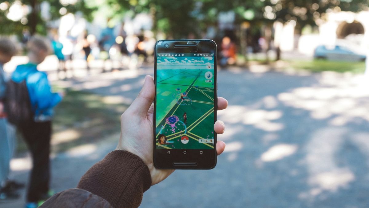 Main tenant un téléphone Pokémon Go lors d'un événement en personne.