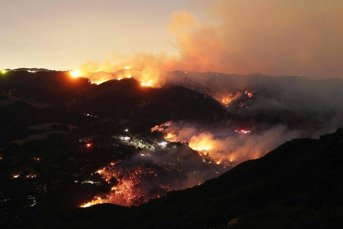 Flames and smoke from the Palisades fire surround a house in Topanga, California, on January 9, 2025.