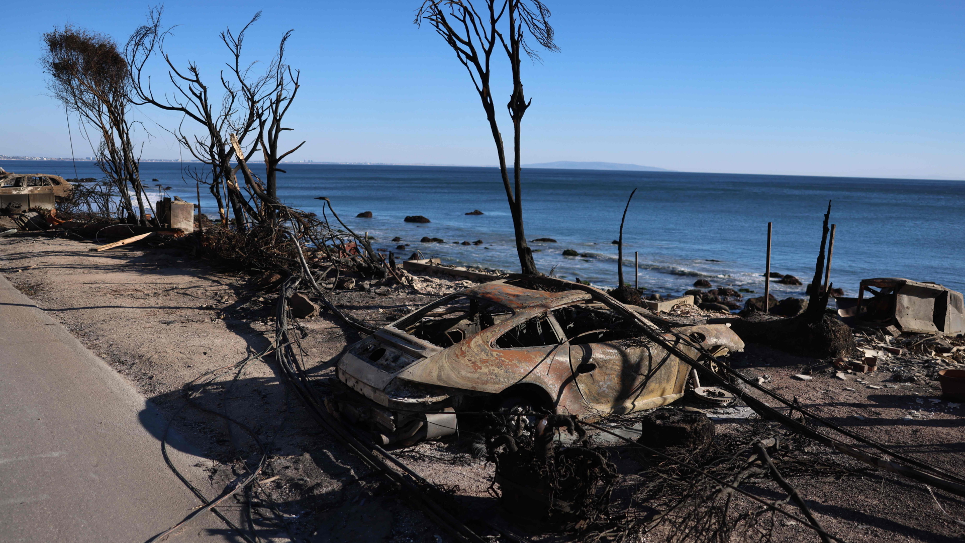 Un auto brûlé sur le bord de la route à Malibu.