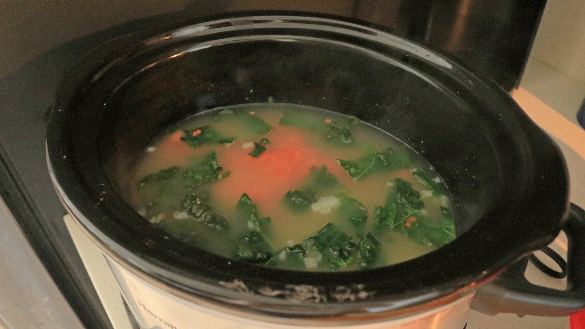 Une mijoteuse avec des ingrédients pour la soupe.