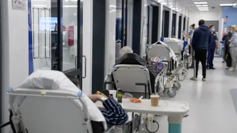 Une ligne de lits dans un couloir d'hôpital