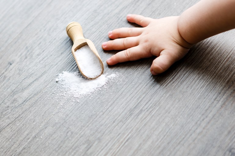 sel blanc dans une cuillère en bois sur la table