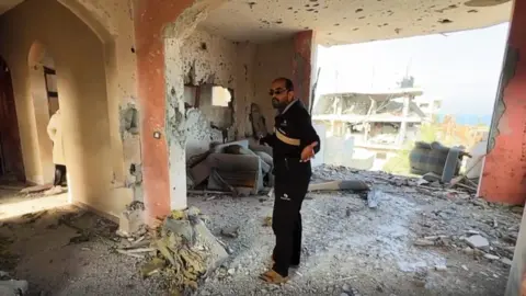 Prof Abu Shiha arrive à ce qui reste de sa maison à Nuseirat.
