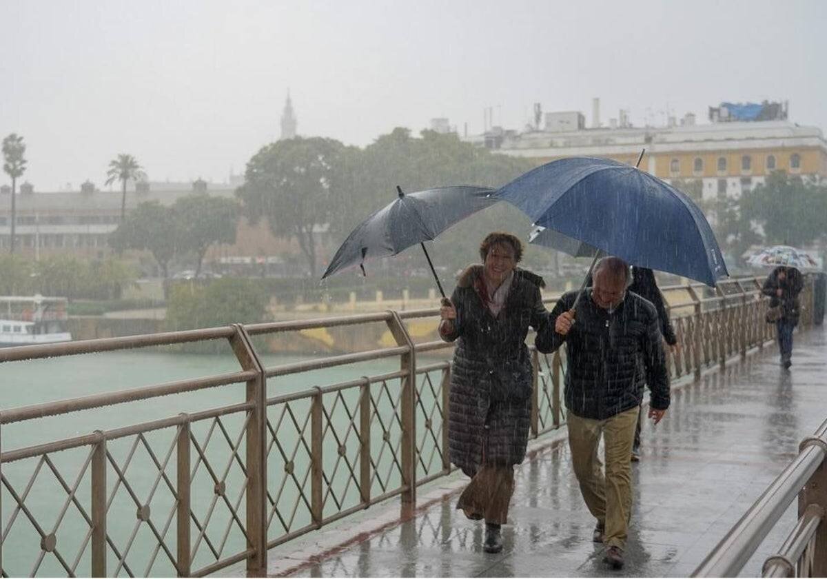 Personnes marchant sous la pluie sur le Pont des Remedios