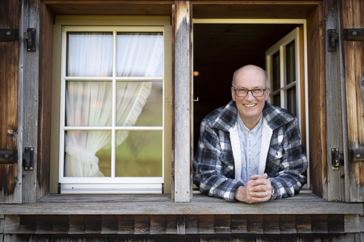 Markus Ritter, Président du Schweizer Bauernverband, souriant depuis une fenêtre sur sa ferme à Altstätten.
