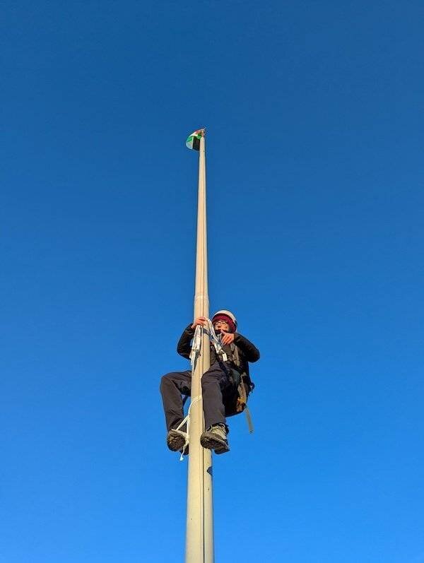 Une activiste remplace le drapeau de Leonardo par celui de la Palestine lors d'une action de protestation à Brescia, 13 janvier 2025 (Ansa)