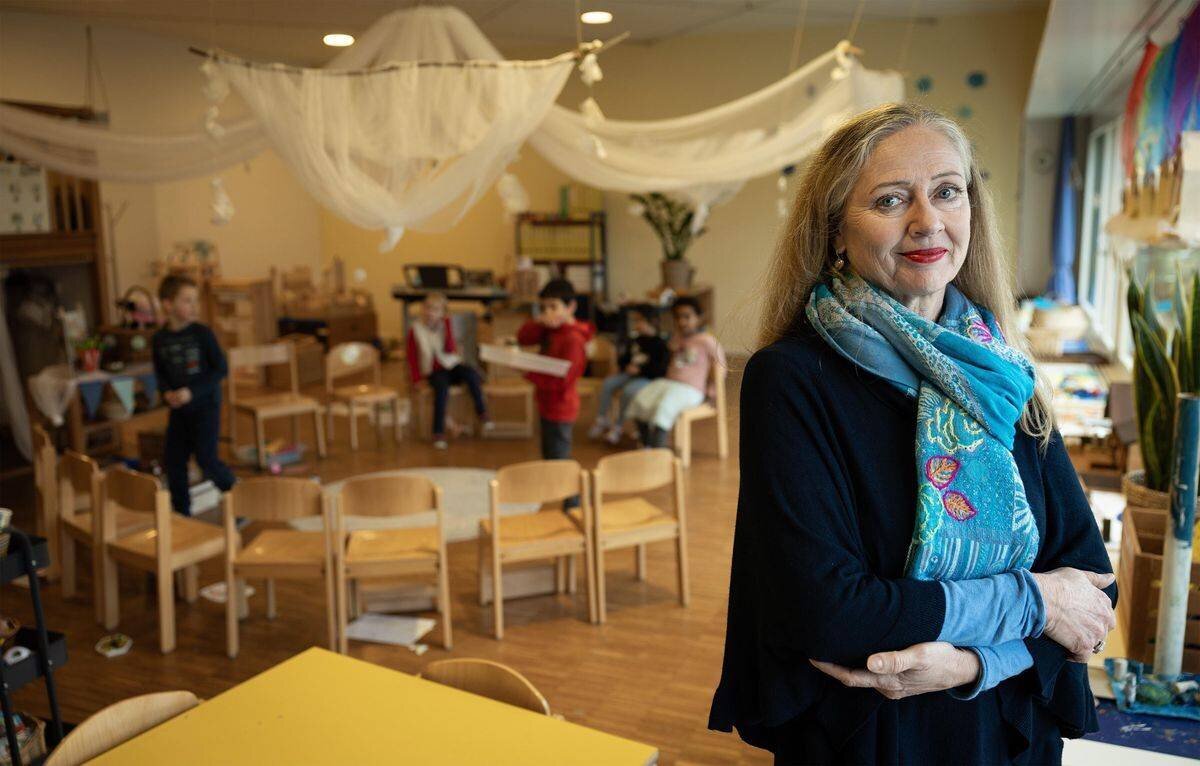 Schulleiterin Gabriella Huber im Kindergarten Lindenfeld in Burgdorf, mit Kindern im Hintergrund beim Spielen und Lernen.
