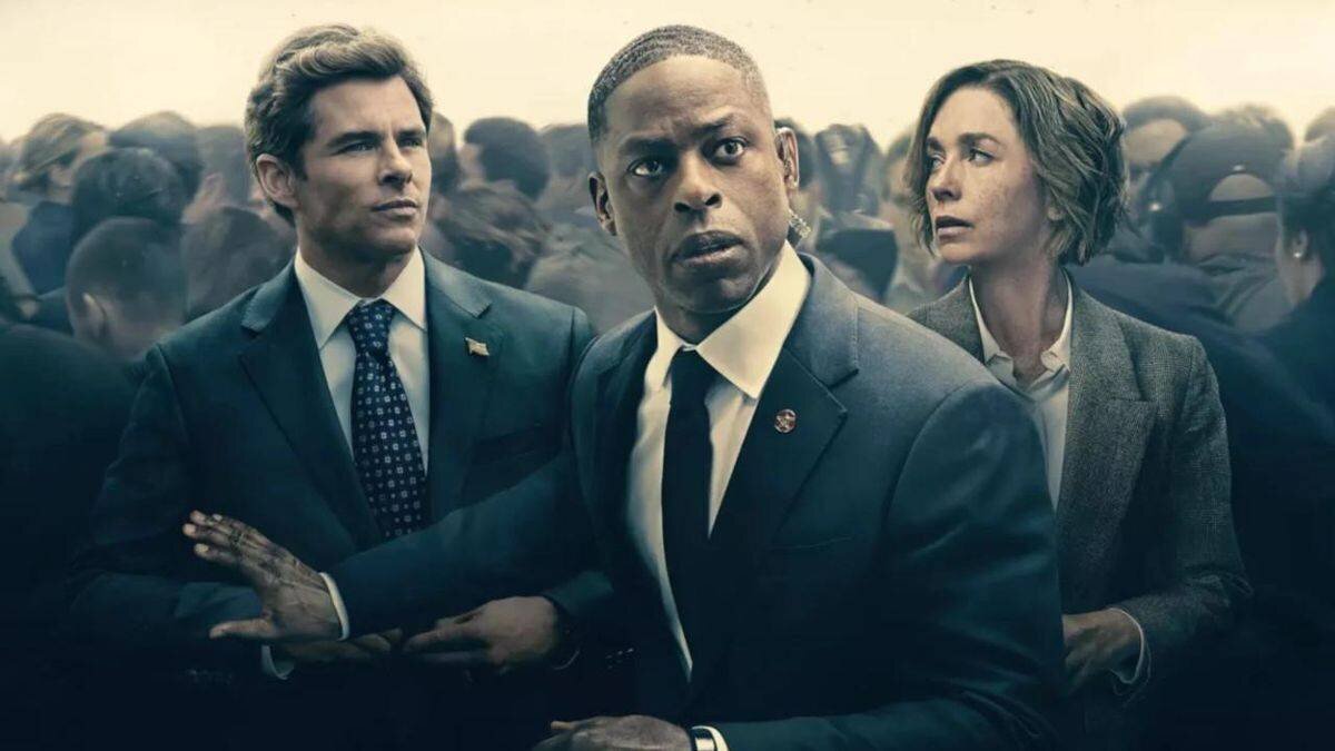 Des personnes en costumes formels, entourées d’une foule floue en arrière-plan.