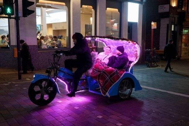Des passagers à l'arrière d'un pedicab traversant Chinatown dans le West End de Londres, le 7 janvier 2025.