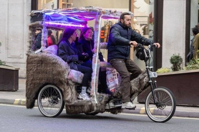 Des acheteurs de Noël dans un pedicab le long de Regent Street, le dernier samedi avant Noël, Londres, Royaume-Uni - 23 décembre 2023.