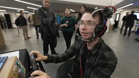 Un homme souriant portant un casque avec des tubes pour diffuser des odeurs.