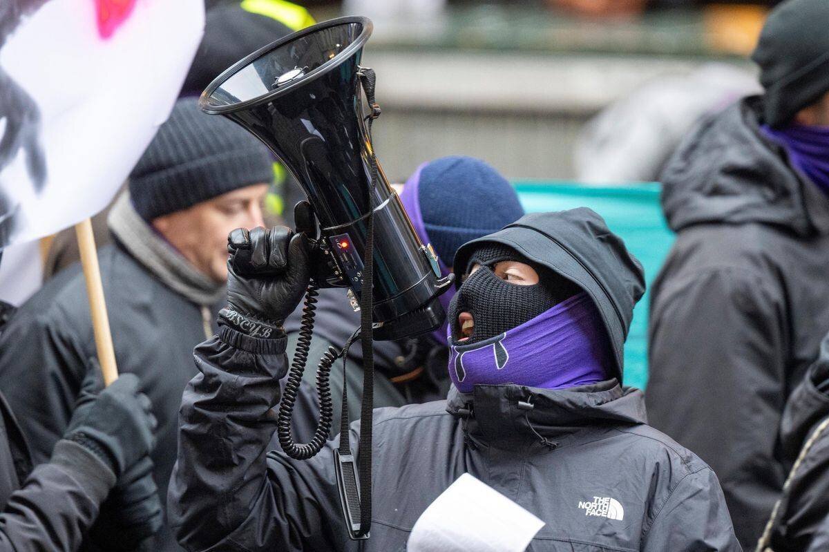 Participants à la manifestation avec un mégaphone.
