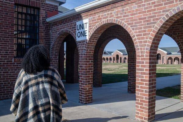 Un chemin avec des entrées en arc et un panneau indiquant 'Unité Un'.