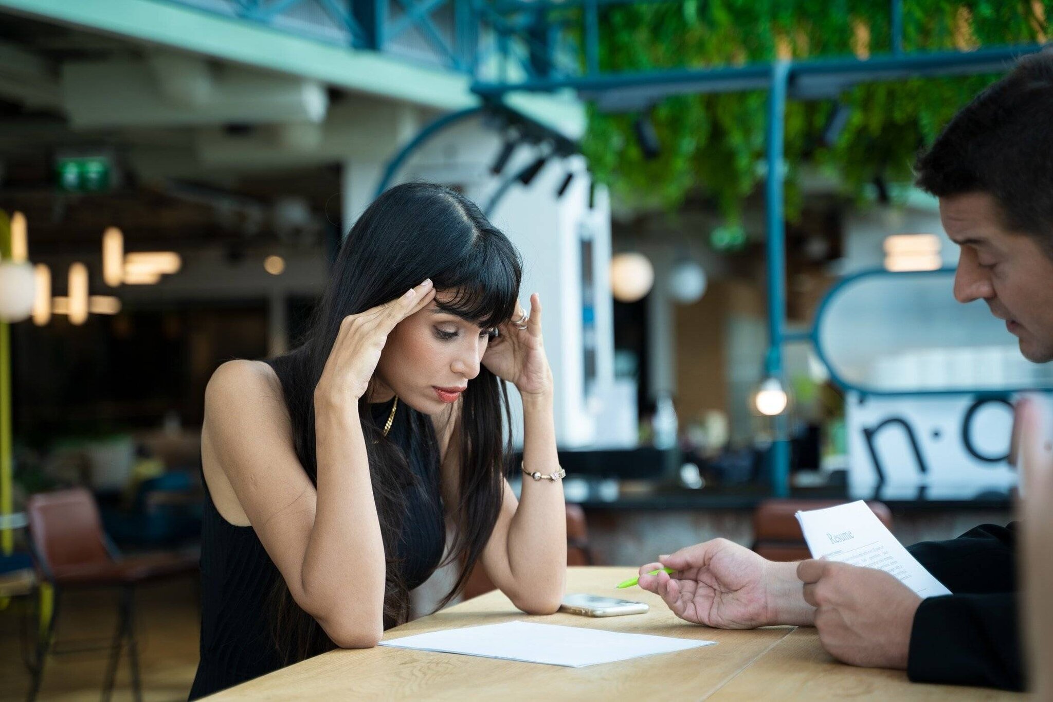 Une femme est chez un entretien d'embauche, visiblement stressée.
